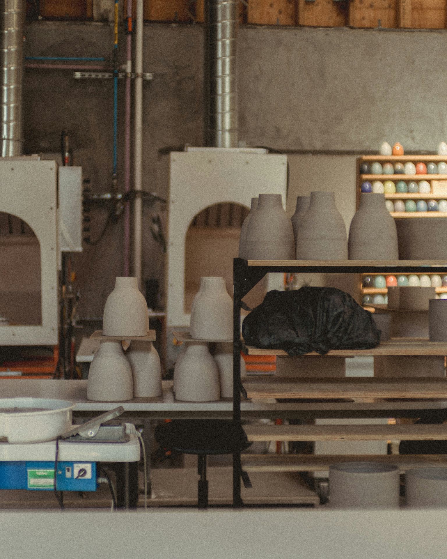 Shelves of unfired pieces in the studio.
